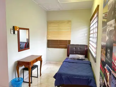 a small bedroom with a bed and a table at G East Ipoh Garden Guesthouse in Ipoh