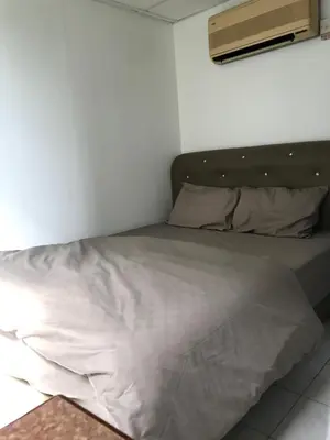 a bed in a room with a white wall at Pangkor Coralbay Resort 201 apartment in Pangkor