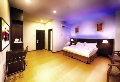 a bedroom with a large bed and purple lighting at ERNES Hotel Alma Bukit Mertajam in Bukit Mertajam