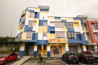 a building with cars parked in a parking lot at Sun Inns Hotel Meru Raya in Chemor
