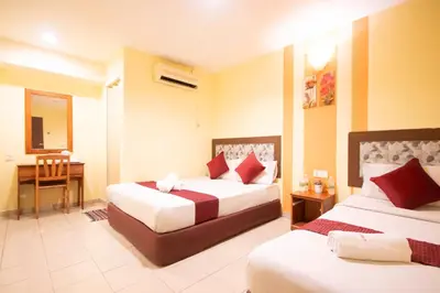 a hotel room with two beds and a desk at Sun Inns Tambun in Kampong Batu Lapan