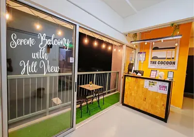 a balcony with a small table and a window at The Cocoon Capsule Hotel in Cameron Highlands