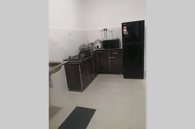 a kitchen with a black refrigerator and a white tile floor at Homestay Tok Ayah, Behrang Jati in Kampung Behrang