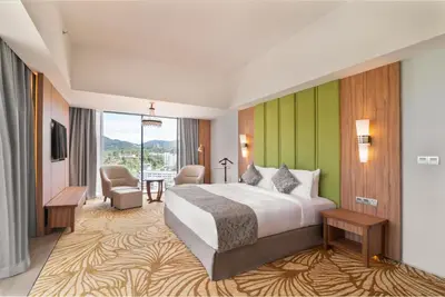 a hotel room with a bed and a large window at Zenith Hotel Cameron in Tanah Rata