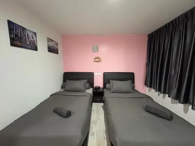 two beds in a room with pink walls at Ipoh Comfortable Rooms Only-Private Bathrooms Indoor Car Parking SY30 in Ipoh