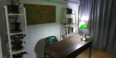 a desk with a lamp in a room with bookshelves at RAHIM HOMESTAY KUALA KANGSAR in Kuala Kangsar