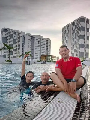 three men sitting in the water in a swimming pool at Grand Meritus Homestay @Penang in Perai
