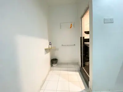 a bathroom with white walls and a tiled hallway at 1108 Hotel Sungkai in Sungkai