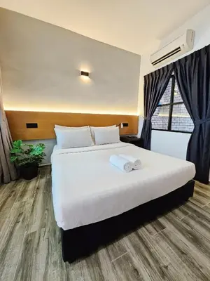 a bedroom with a bed with two towels on it at Georgetown Inn by Sky Hive in George Town
