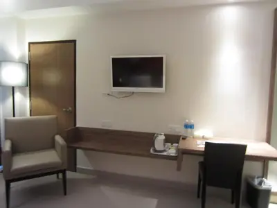 a hotel room with a desk and a tv on the wall at D Hotel in Seri Iskandar
