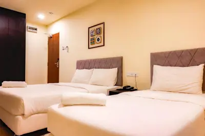 a hotel room with two beds with white sheets at Bishop Hotel in George Town