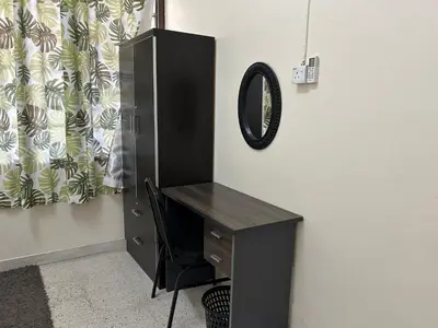 a black desk with a mirror and a black cabinet at Minden Stay in Gelugor