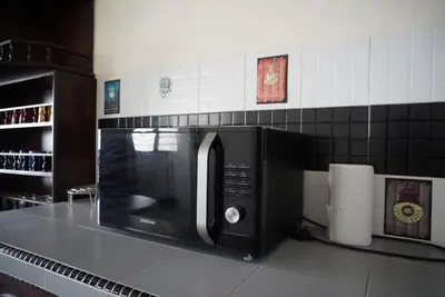 a microwave oven sitting on top of a kitchen counter at Minden Stay in Gelugor