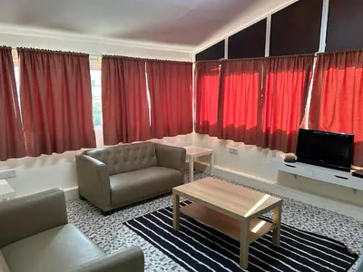 a living room with red curtains and a couch and a table at Minden Stay in Gelugor