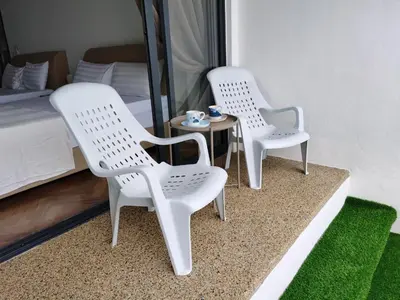 two white chairs and a table in a bedroom at Landmark Stunning High Floor Coast View Studio #Netflix #Fast Wifi in Tanjong Tokong