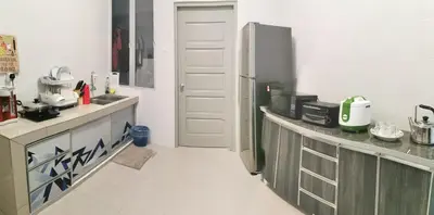 a kitchen with a refrigerator and a counter top at Coco HomeStay \u65c5\u4eba\u306e\u5bb6@The Venus Sitiawan Perak in Sitiawan