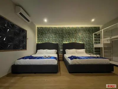 two beds sitting next to each other in a bedroom at BMC Hotel in Ipoh