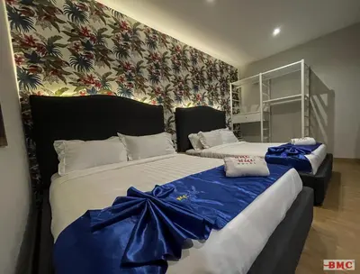 two beds in a room with blue bows on them at BMC Hotel in Ipoh
