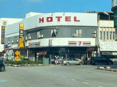 a hotel with cars parked in a parking lot at Lih Pin Hotel in Sungai Petani