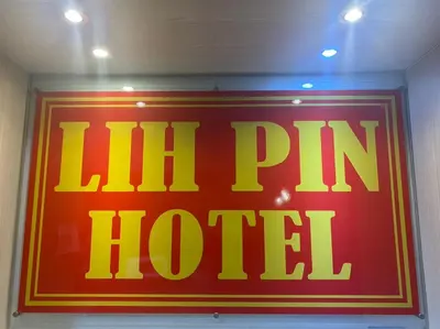 a neon sign that says ill pin hotel on a wall at Lih Pin Hotel in Sungai Petani
