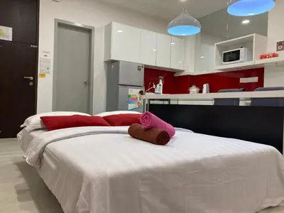 a large white bed with a stuffed animal on it at Straits Garden Suite Jelutong Georgetown in George Town