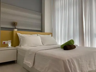 a bedroom with a bed with a green pillow on it at Straits Garden Suite Jelutong Georgetown in George Town