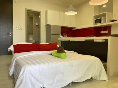 a bedroom with a bed with a cat laying on it at Straits Garden Suite Jelutong Georgetown in George Town