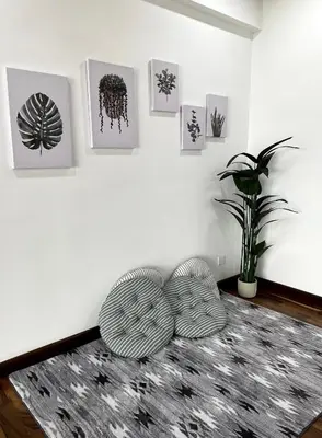 a living room with two chairs and a wall with pictures at The Venus - Spacious Wooden TOP Floor Apartment in Sitiawan
