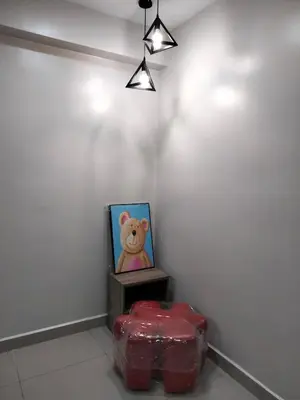 a teddy bear picture and a red stool in a room at WL Homestay in Sitiawan