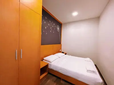 a small bedroom with a bed and a cabinet at Nova Apartments near Kea Farm in Brinchang