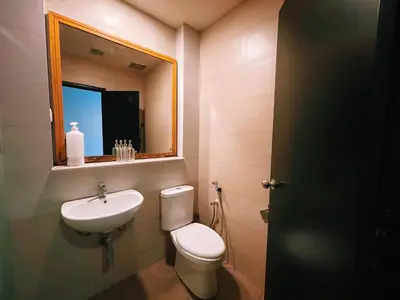 a bathroom with a toilet and a sink and a mirror at Nova Apartments near Kea Farm in Brinchang