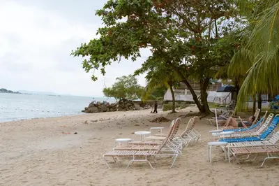 a group of chairs and tables on a beach at J Beach Suites At Rainbow Paradise in Tanjung Bungah