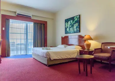 a hotel room with a bed and a chair at J Beach Suites At Rainbow Paradise in Tanjung Bungah