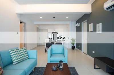 a living room with a blue couch and a table at Jazz Suites Apartment Penang By Jazz Service Suite in Bagan Jermal