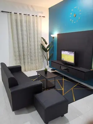 a living room with a couch and a television at LYNN HOMESTAY SERI ISKANDAR in Seri Iskandar