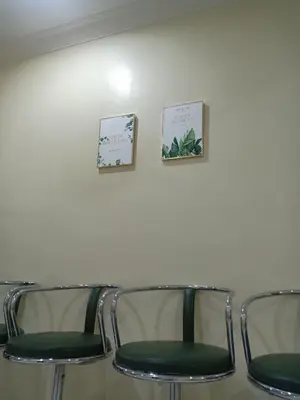 three chairs in a waiting room with paintings on the wall at KH Homestay Comfy N Calm in Seri Manjung