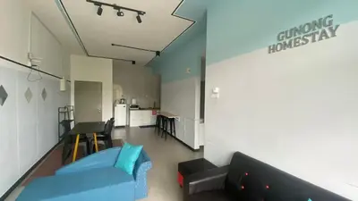 a living room with a blue couch and a table at GUNONG HOMESTAY at Golden Hills CameronHighlands in Cameron Highlands