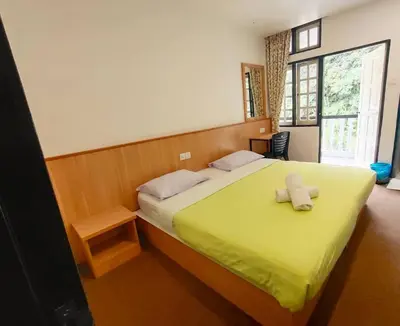 a bedroom with a large bed with a yellow blanket at Hillview Inn Cameron Highlands PROMO in Tanah Rata
