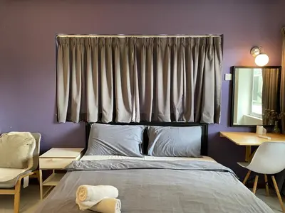 a bedroom with a bed and a window with curtains at Aurora Court Service Apartment in George Town