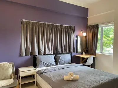 a bedroom with a bed and a window and a desk at Aurora Court Service Apartment in George Town