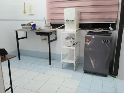 a small kitchen with a sink and a refrigerator at Homestay Idaman Penang in Permatang Pauh