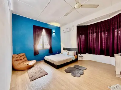 a bedroom with a bed and a blue wall at Entire Residential House Alma Bukit Mertajam Spacious 4 bedroom in Bukit Mertajam