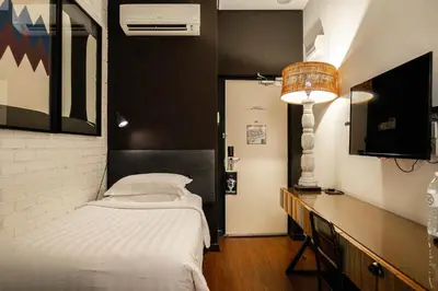 a small bedroom with a bed and a television at M Boutique Hotel in Ipoh