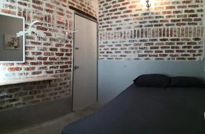 a bedroom with a brick wall and a bed at H&T Vintage Decor Homestay in Ipoh