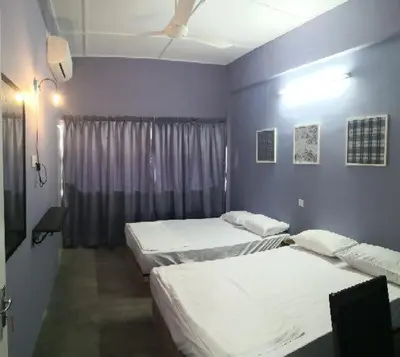 a room with three beds and a purple wall at H&T Vintage Decor Homestay in Ipoh