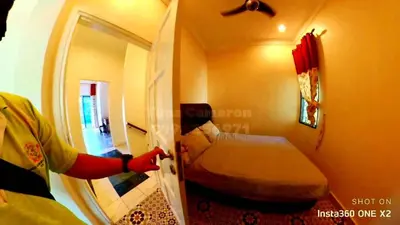 a person is reaching into a room with a bed at Tuna Cameron Homstay in Brinchang