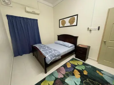 a bedroom with a bed and a blue curtain at No 61 Nazirin Homestay Tmn Indah Raya 2 Manjung Lumut in Lumut