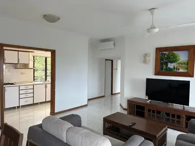 a living room with a couch and a flat screen tv at Beach Resort 19 Home Stay SRI SAYANG APARTMENT BATU FERRINGHI 3BEDROOM in Batu Ferringhi
