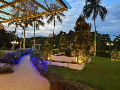 a garden with christmas lights and christmas trees at Beach Resort HOME STAY SRI SAYANG 05 APARTMENT BATU FERRINGHI 2BEDROOM in Batu Ferringhi