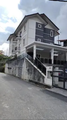a large white building on the side of a street at CAMERON TROPICA HOMESTAY in Cameron Highlands